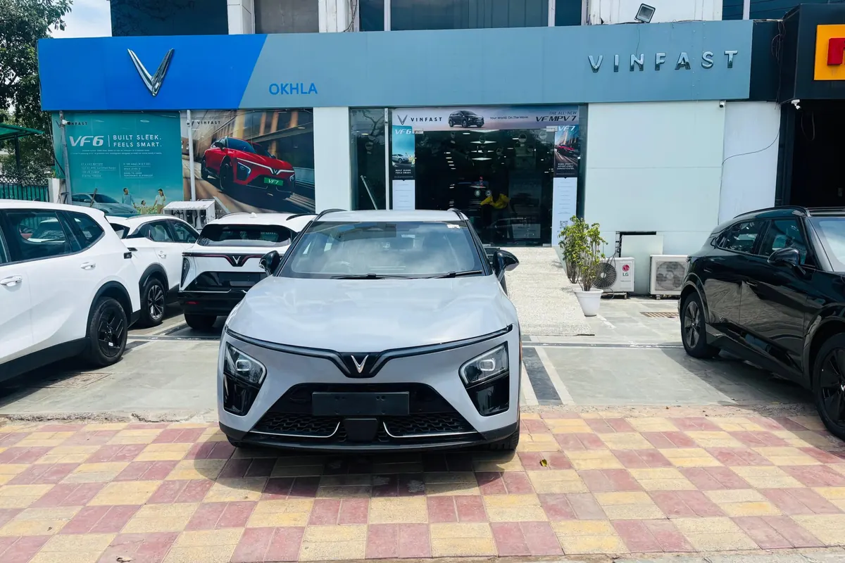 YouWe VinFast Okhla showroom from the street, with a VF 6 and other VinFasts parked outside